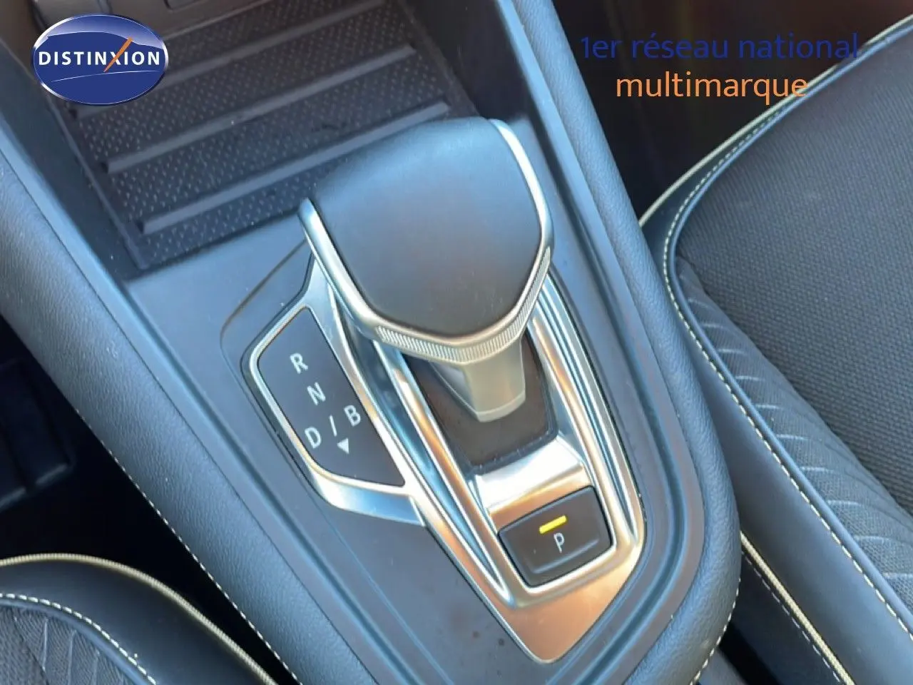 Gros plan sur la commande de boîte automatique de la Renault Symbioz 2025, finition bleu Iron Metal, intérieur tissu noir.