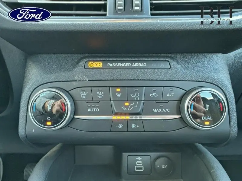 Vue rapprochée du tableau de bord du Ford Kuga 2023, montrant la console de climatisation avec réglages digitaux et boutons rétroéclairés.