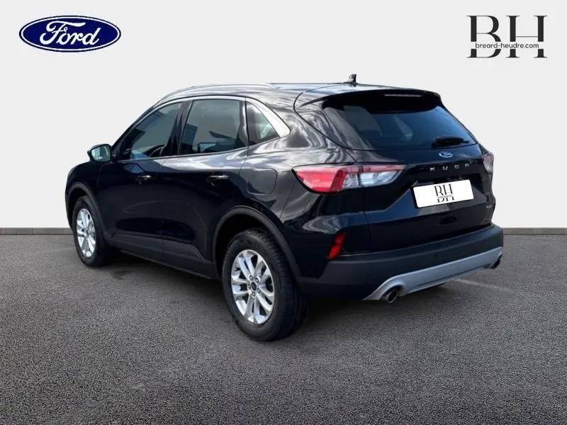 Vue 3/4 arrière droite du Ford Kuga 2023 noir Agate métallisé avec jantes alu et double sortie d'échappement.