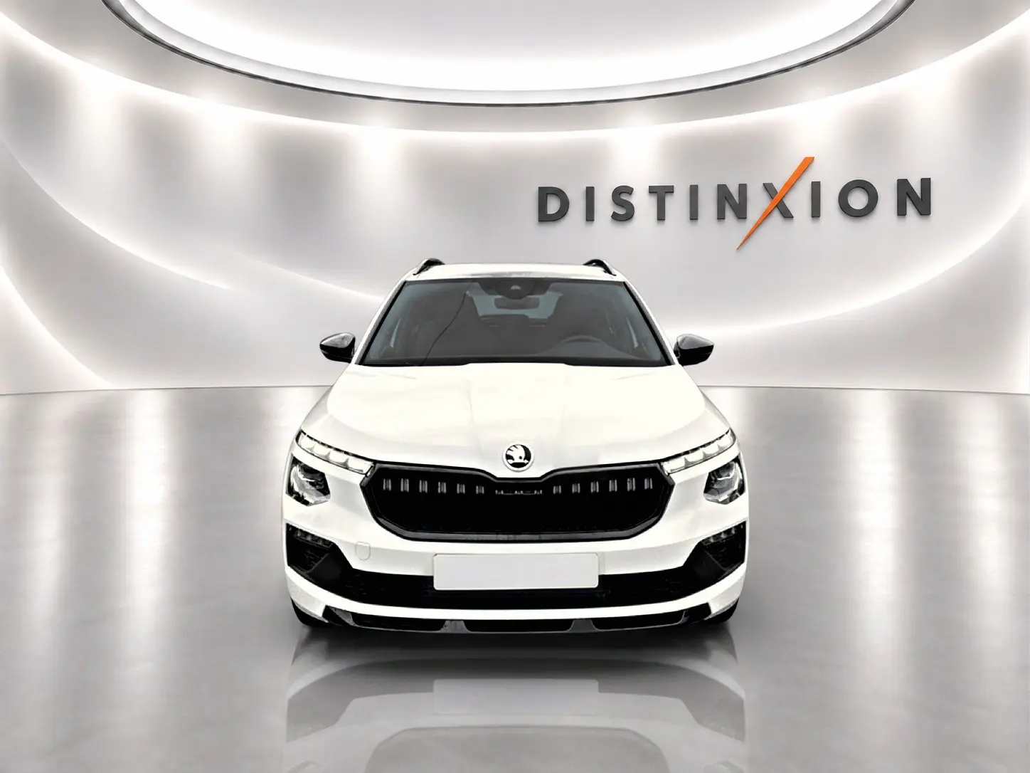 Vue frontale d'un Skoda Kamiq blanc nacré avec calandre noire et signature lumineuse LED, en studio épuré.
