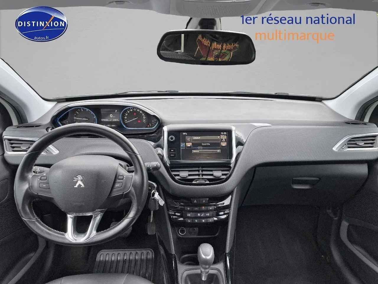 Intérieur de la Peugeot 2008 blanc nacré de 2015, vue frontale sur le tableau de bord et volant cuir noir.