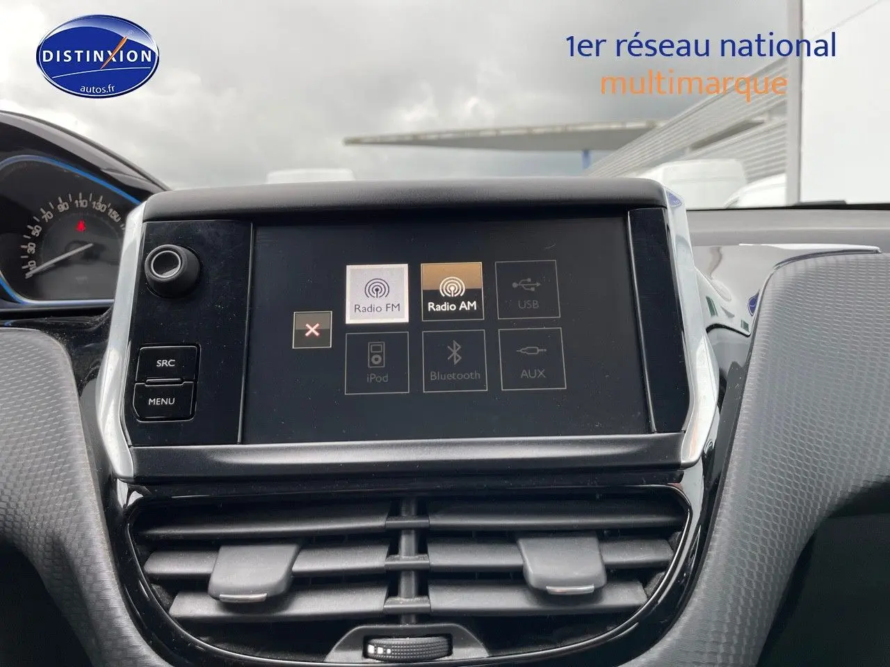 Écran tactile central du tableau de bord d'une Peugeot 2008 blanc nacré, avec commandes radio FM et AM visibles.