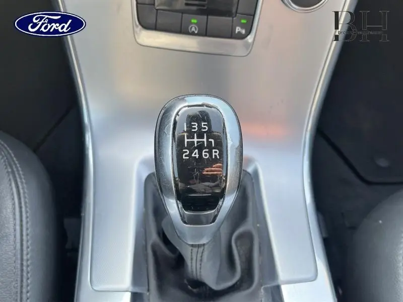 Levier de vitesses manuel noir et chrome vu de dessus dans un intérieur gris argenté.