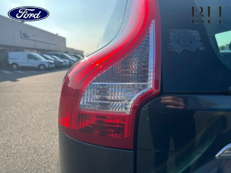 Gros plan sur le feu arrière droit d’un Volvo XC60 gris Savile, avec reflet de lumière et partie de la lunette arrière visible.