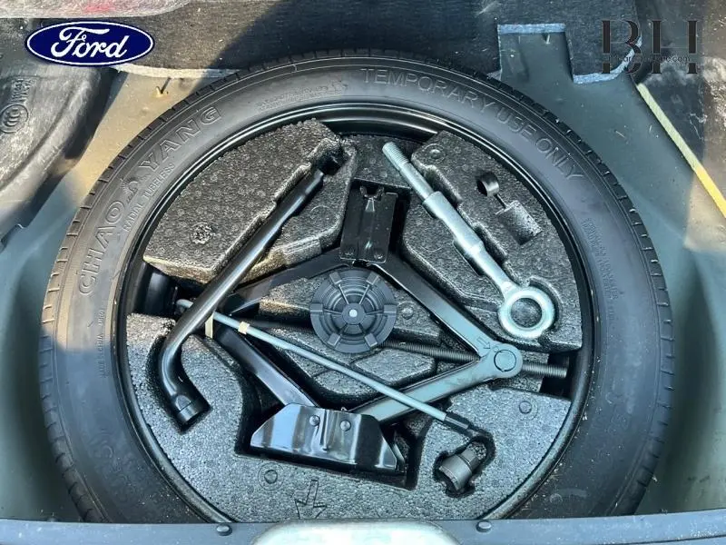 Pneu de secours avec outils de changement rangés dans le coffre d'un Volvo XC60 gris Savile 2016.