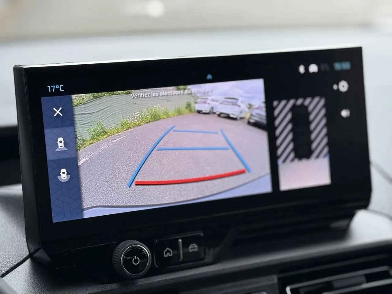 Écran tactile intérieur montrant la caméra de recul du Citroën Berlingo Multispace gris acier, avec lignes de guidage colorées.