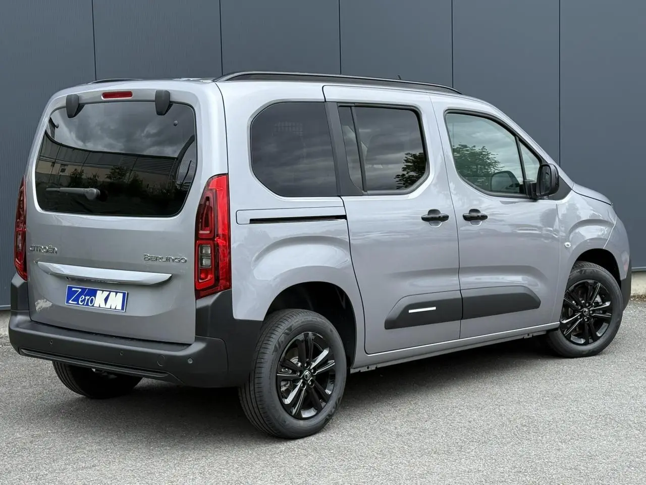 Vue 3/4 arrière droite du Citroën Berlingo Multispace gris acier avec jantes alliage noires et lunette arrière ouvrante.