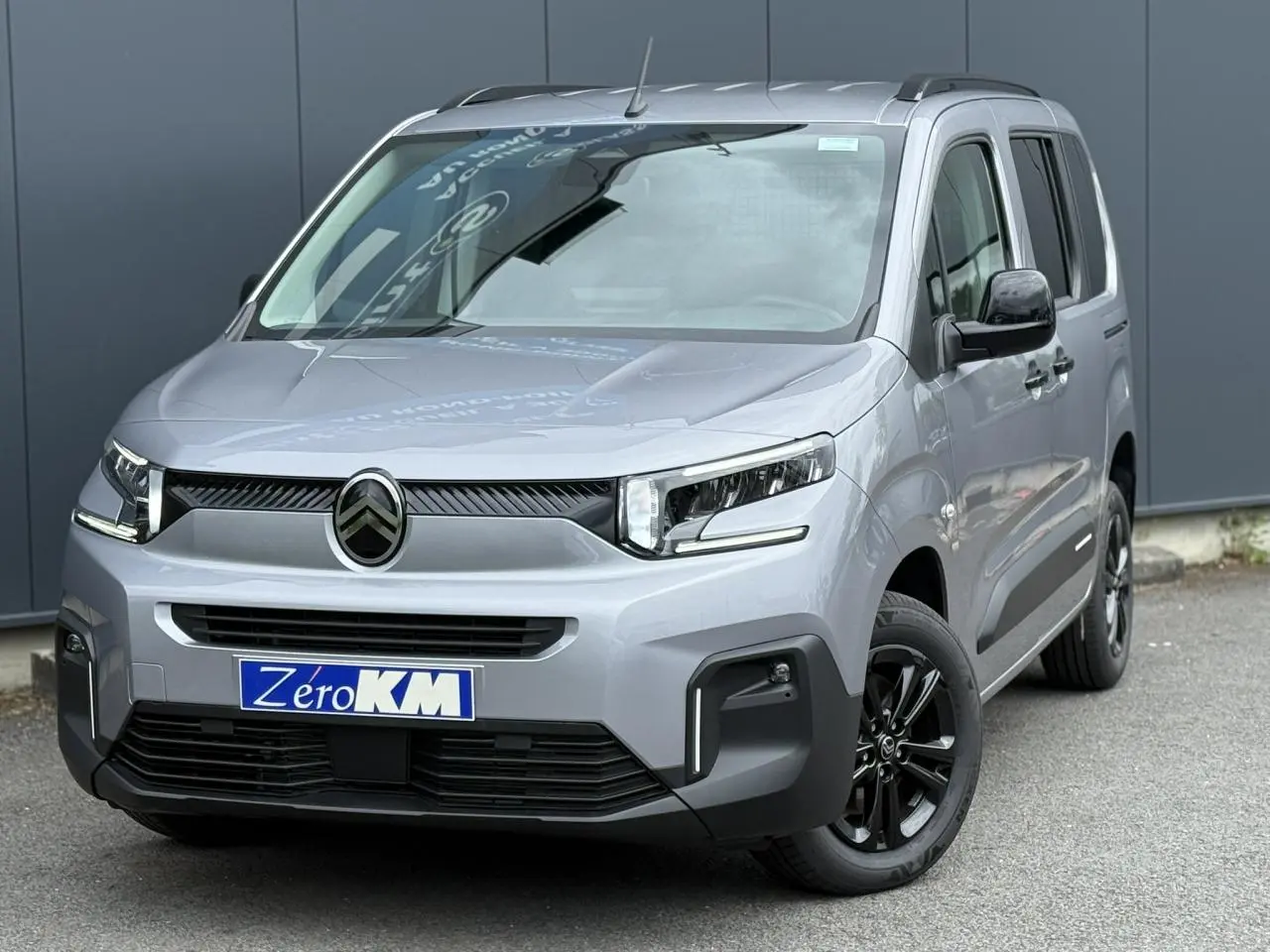Citroën Berlingo Multispace gris acier en 3/4 avant droit avec jantes noires et lunette arrière ouvrante.