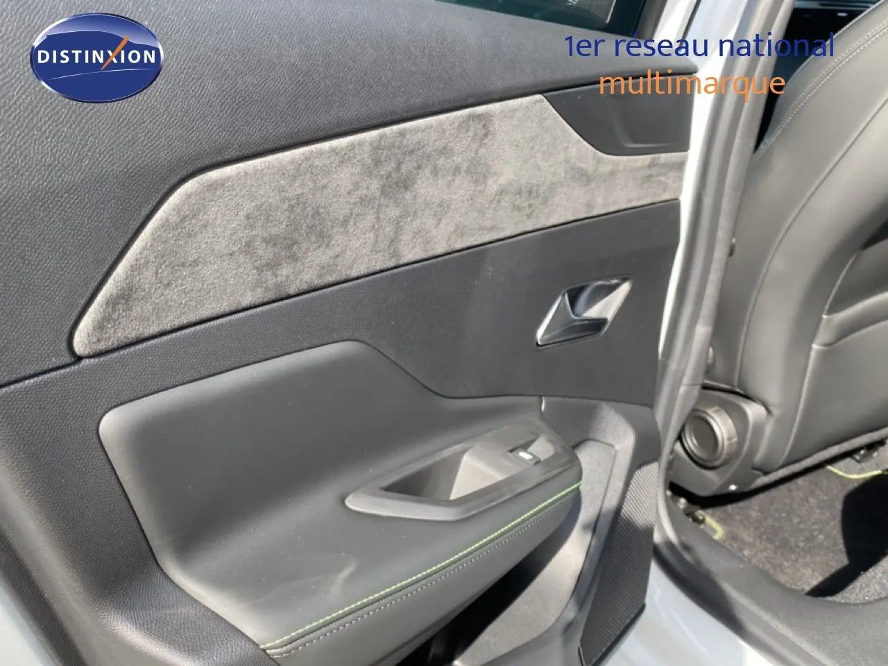 Vue intérieure côté gauche de la porte arrière d'une Peugeot 308 blanche, avec garniture tissu gris et cuir noir.