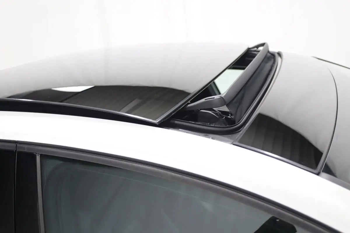 Détail du toit panoramique ouvert sur une Volkswagen Golf blanche, vue de dessus côté gauche.