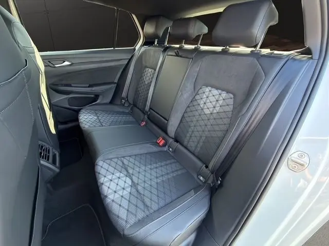 Vue côté droit de la banquette arrière en tissu et cuir noir avec motifs géométriques dans une Volkswagen Golf blanche 2025.