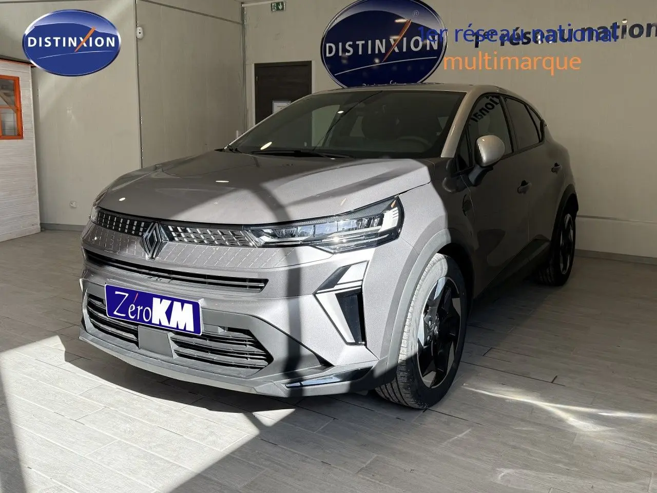 Renault Captur 2025 gris Cassiopée métal en 3/4 avant droit, avec toit gris et jantes noires distinctives.