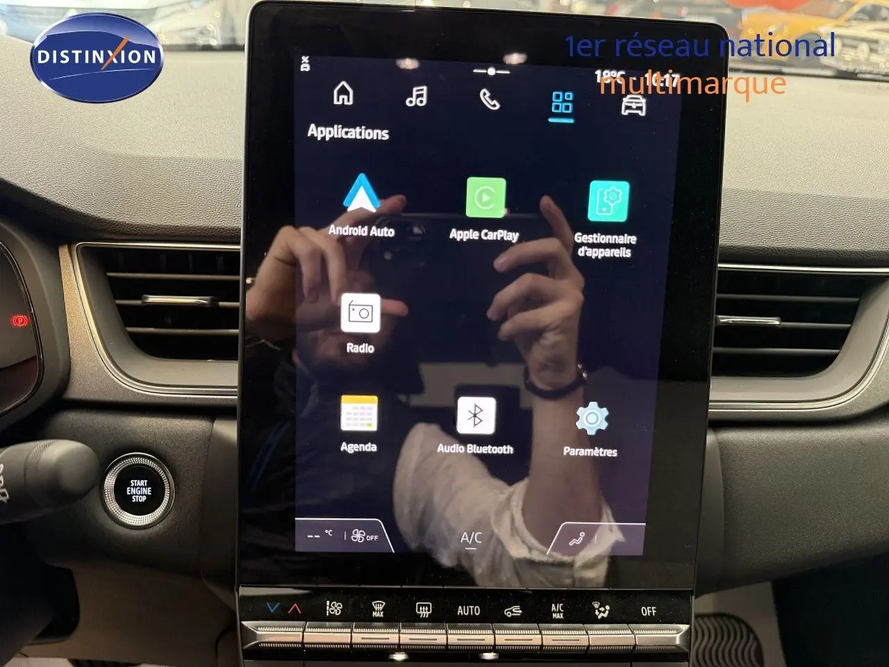 Vue intérieure centrée sur l'écran tactile du tableau de bord du Renault Captur gris Cassiopée, affichant les applications connectées.