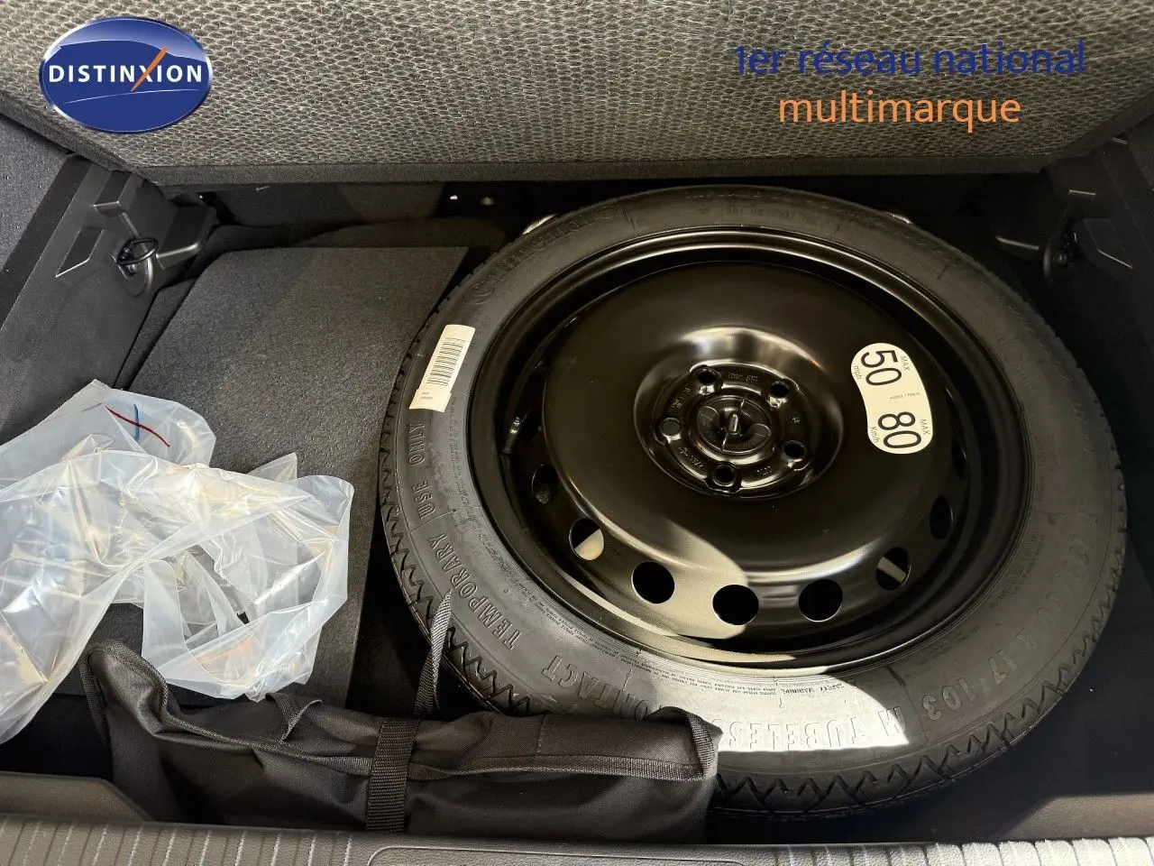 Vue rapprochée de la roue de secours noire dans le coffre du Renault Captur gris Cassiopée Métal.