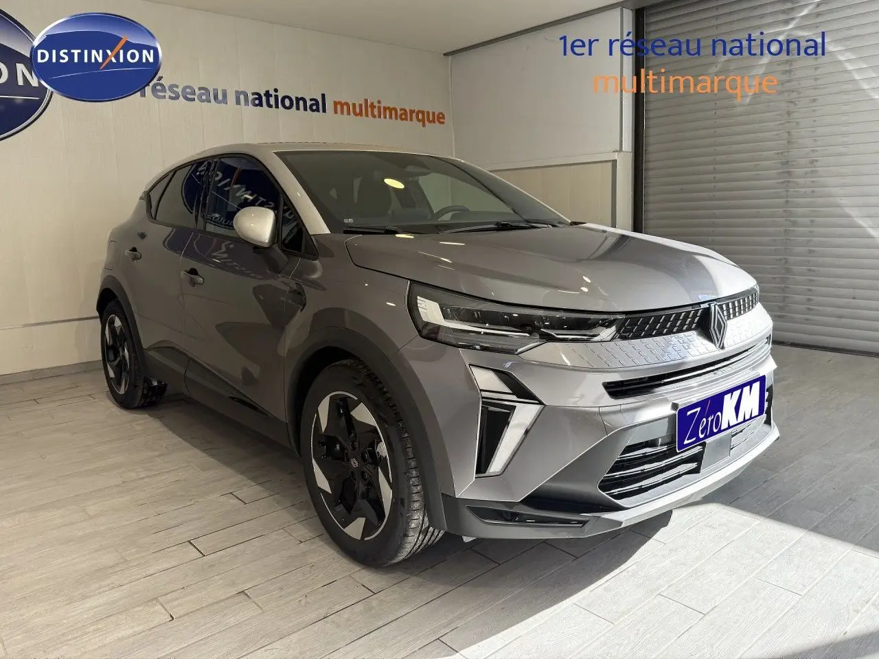 Renault Captur 2025 gris cassiopée métal avec toit gris, vue 3/4 avant, jantes bi-ton et calandre moderne.