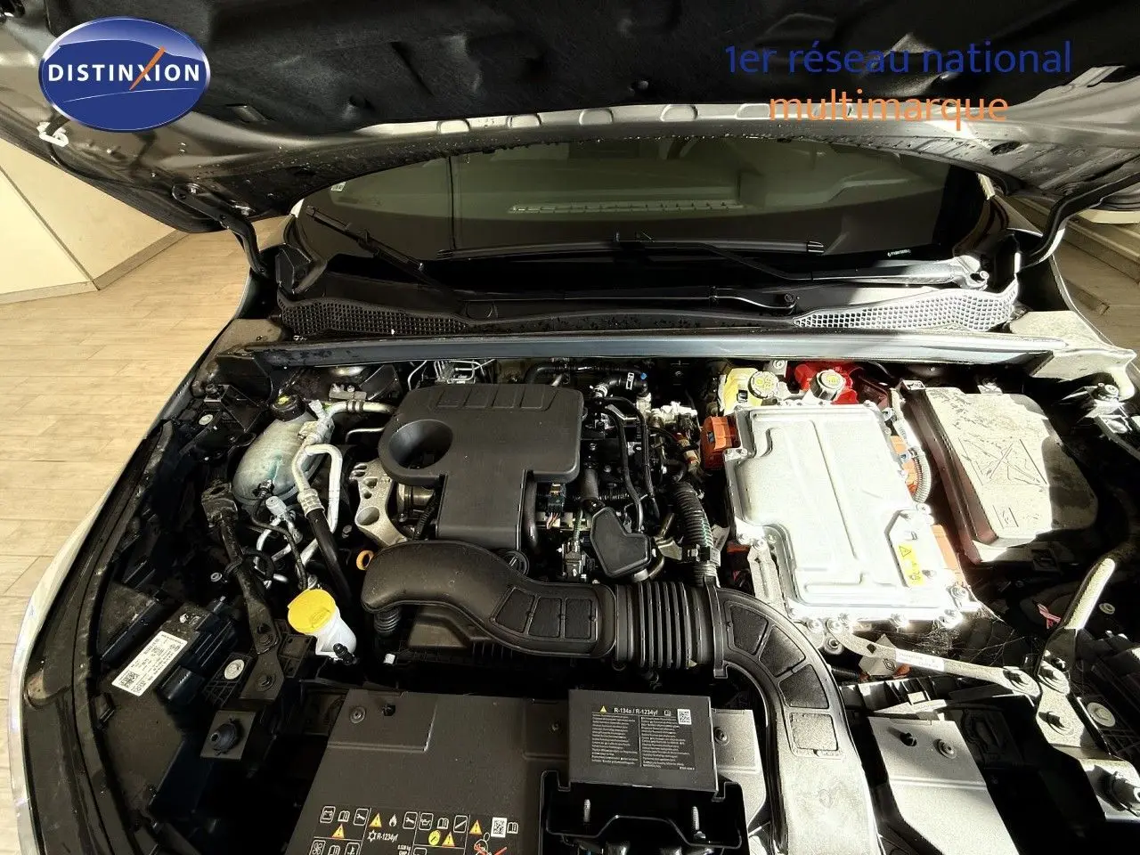 Moteur hybride Renault Captur 1.6 E-TECH vu de dessus sous le capot ouvert, détails des composants visibles.