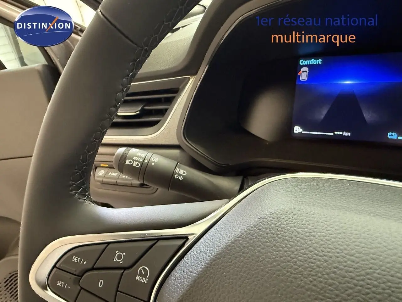 Vue rapprochée du volant et du tableau de bord numérique du Renault Captur gris Cassiopée, affichant le mode Confort.