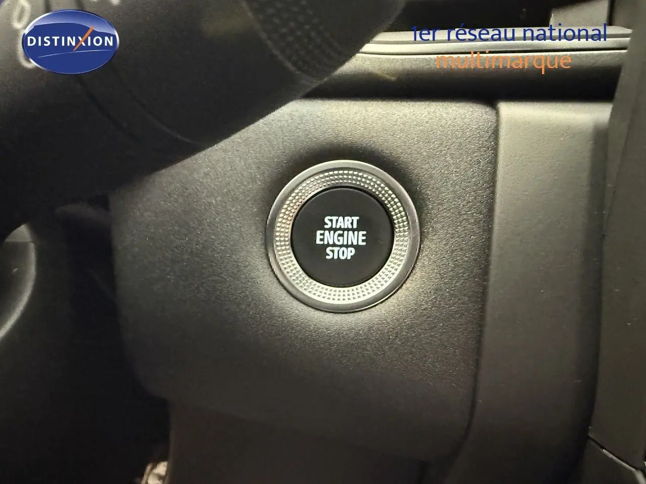 Gros plan sur le bouton Start Engine Stop du tableau de bord intérieur du Renault Captur gris Cassiopée 2025.