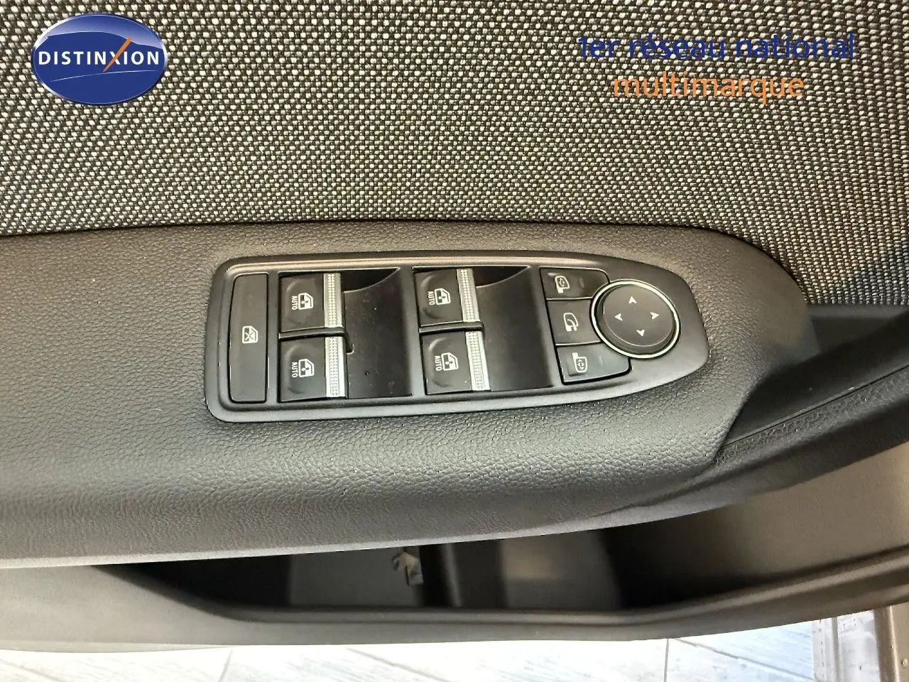 Gros plan sur les commandes des vitres électriques et rétroviseurs du côté gauche d'une Renault Captur gris cassiopée métal 2025.