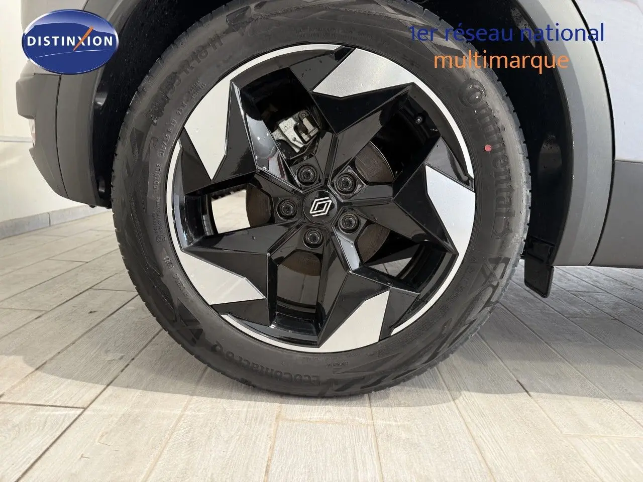 Gros plan sur la roue avant droite du Renault Captur 2025, jante bi-ton noire et argent au design géométrique.