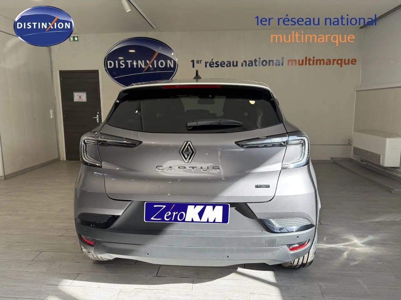 Vue arrière d'un Renault Captur gris Cassiopée Métal avec toit gris, en intérieur dans un showroom.