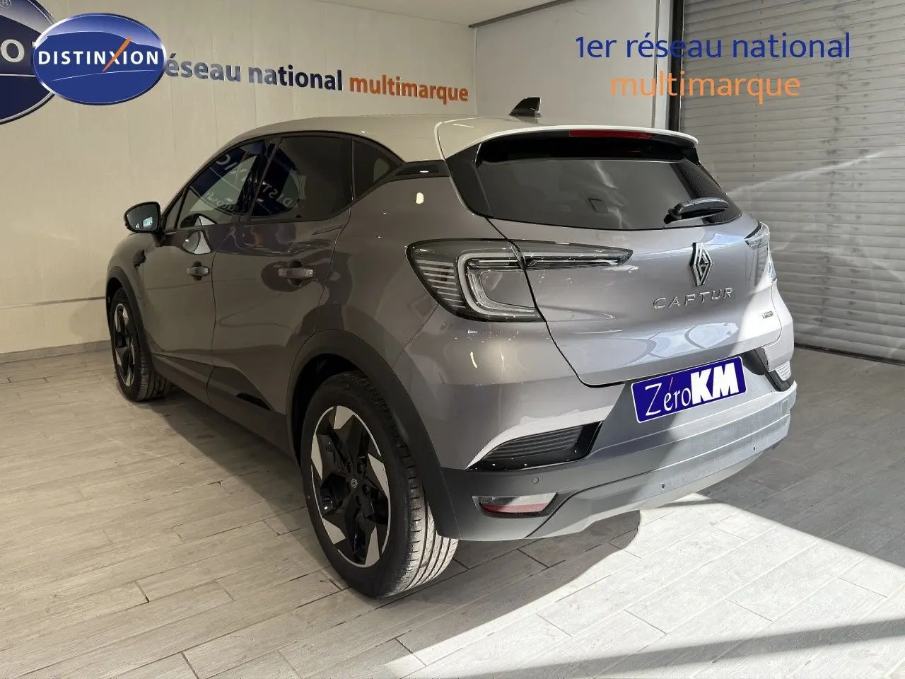 Vue 3/4 arrière droite du Renault Captur gris Cassiopée métal avec toit gris, jantes noires et feux LED distinctifs.