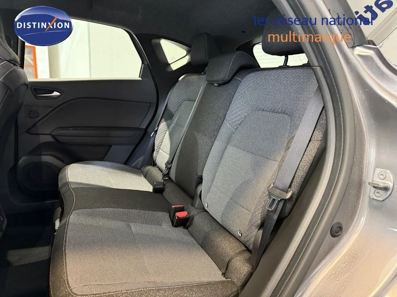 Vue intérieure de la banquette arrière du Renault Captur gris cassiopée, avec sellerie tissu gris et noir.