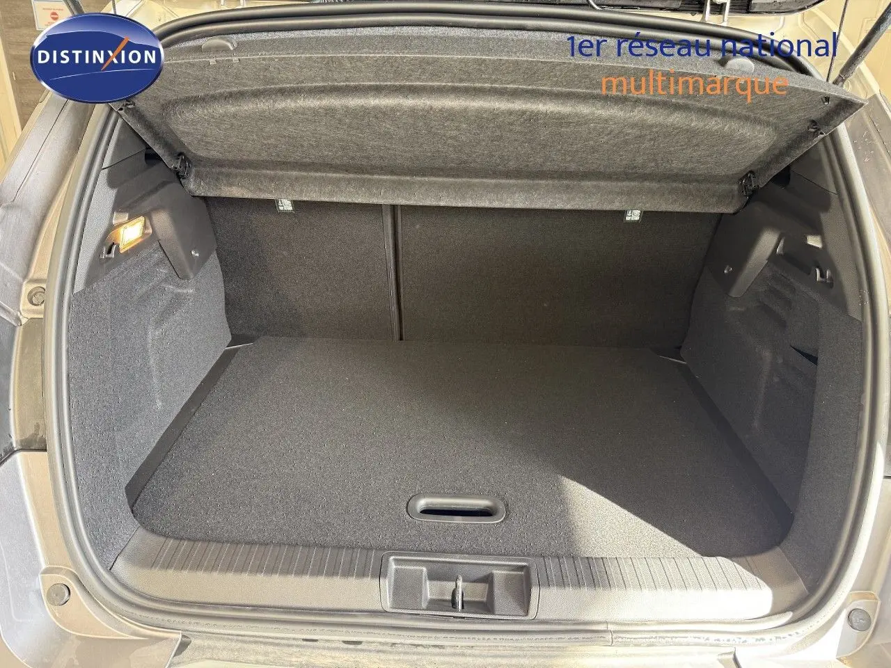 Coffre ouvert du Renault Captur gris Cassiopée métal, montrant l’espace de rangement intérieur vide et la trappe de plancher.