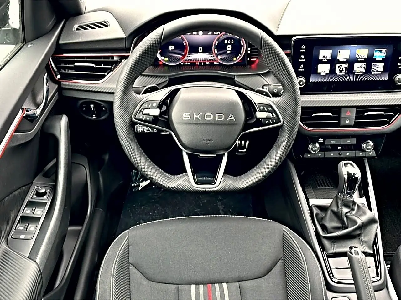 Vue intérieure centrée sur le volant sport et tableau de bord numérique du Skoda Kamiq Monte Carlo 2026, finition noire.
