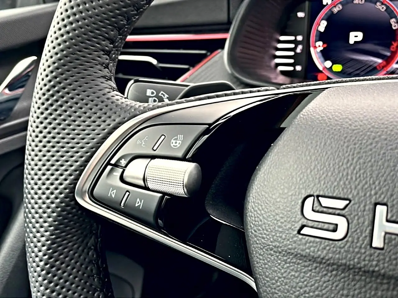 Gros plan sur le volant cuir perforé noir du Skoda Kamiq Monte Carlo avec commandes multifonctions et détails métalliques.