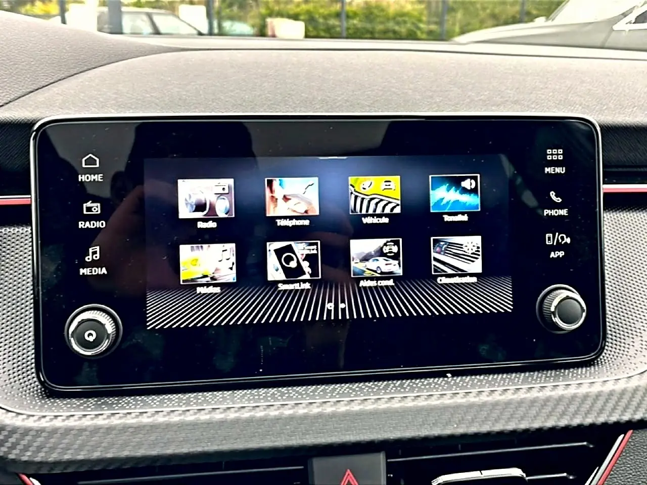 Écran tactile central du tableau de bord du Skoda Kamiq blanc nacré, avec interface multimédia affichée.
