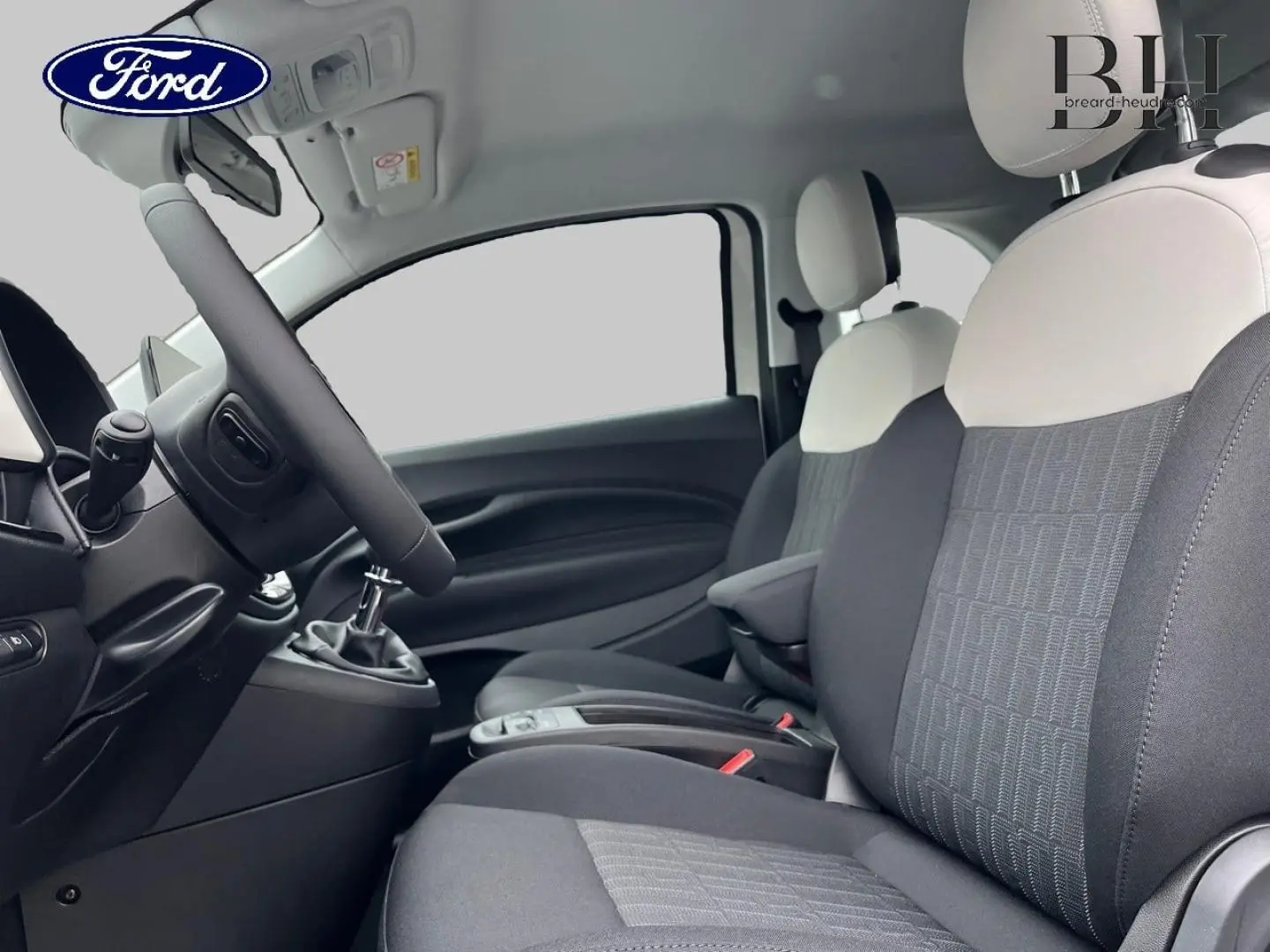 Vue intérieure côté conducteur de la FIAT 500 Ice White pastel, sièges bicolores noir et blanc avec volant multifonction.