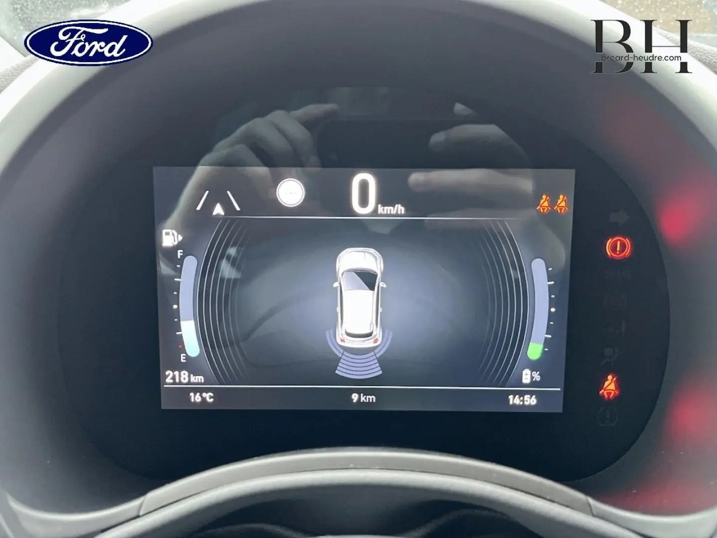 Tableau de bord numérique de la Fiat 500 Ice White pastel, affichant la vitesse à 0 km/h et les capteurs de proximité actifs.