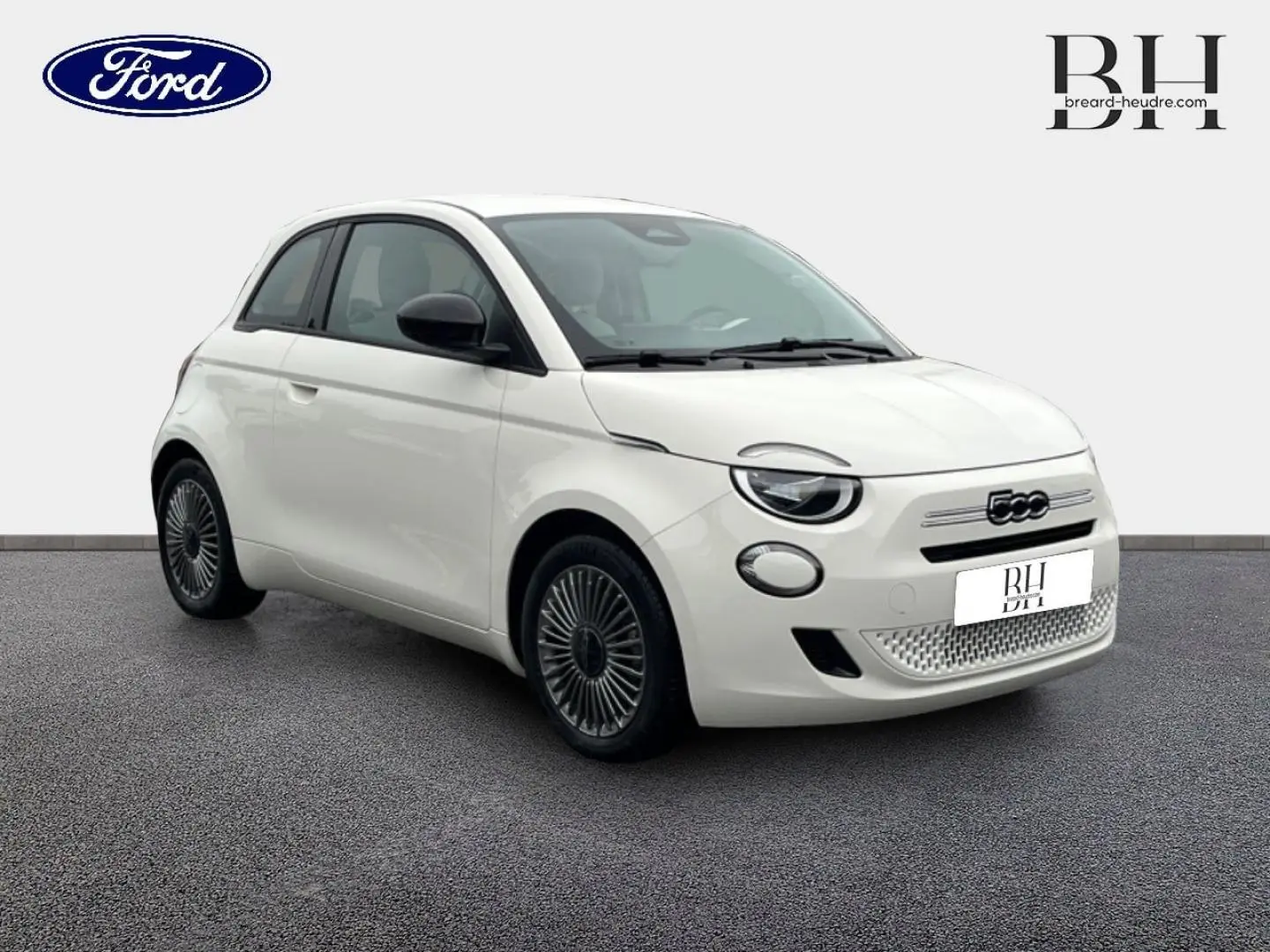 Vue 3/4 avant d'une FIAT 500 Ice White pastel avec jantes alu et détails noirs contrastants sur fond neutre.