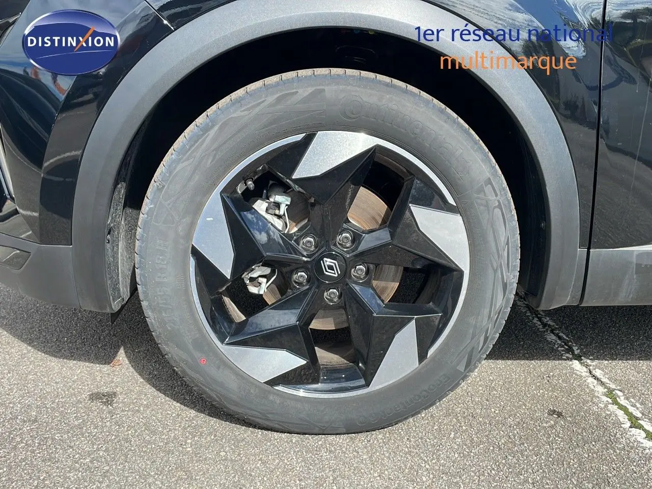 Gros plan sur la roue avant gauche du Renault Captur noir étoile métal avec jante diamantée bicolore.