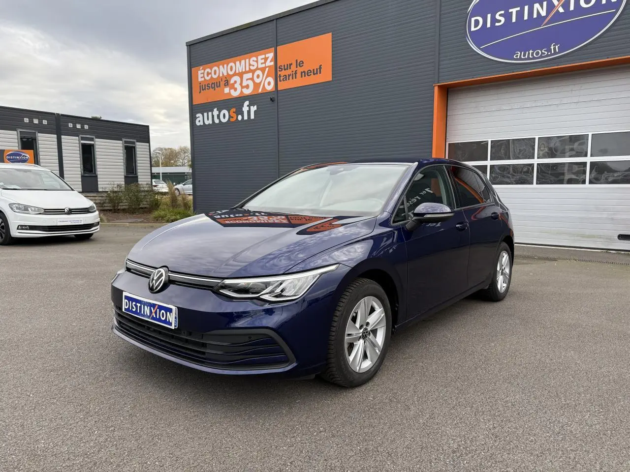 Volkswagen Golf 2.0 TDI 2023 bleu Atlantique métallisé vue 3/4 avant sur parking devant un garage