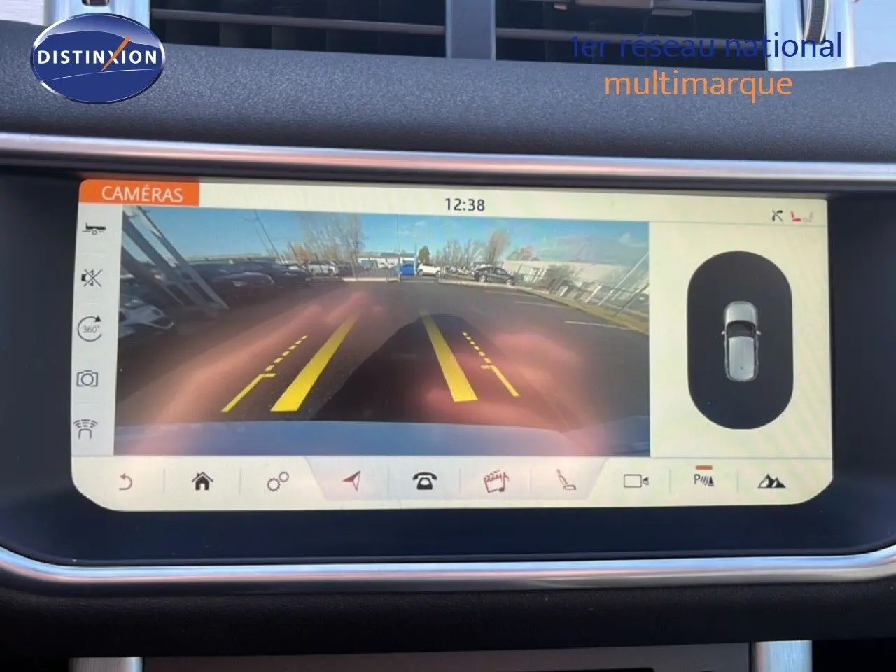 Écran de caméra de recul du Range Rover Evoque blanc 2017, affichant les lignes de guidage jaunes et la vue arrière du parking.