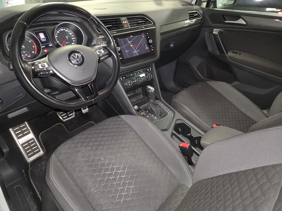 Intérieur noir du Volkswagen Tiguan 2019, vue côté conducteur avec tableau de bord et console centrale tactile.