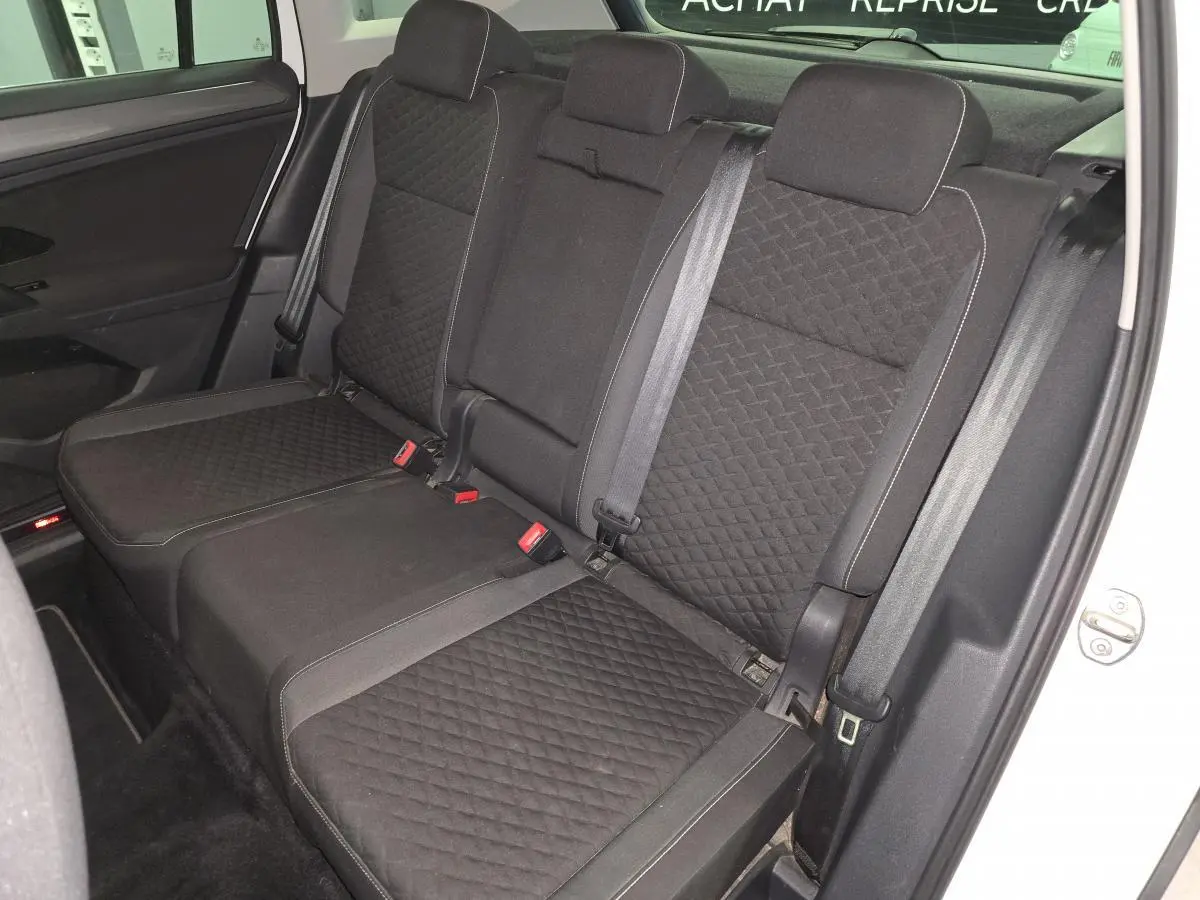Vue intérieure côté droit sur la banquette arrière noire en tissu matelassé du Volkswagen Tiguan blanc 2019 Confortline.