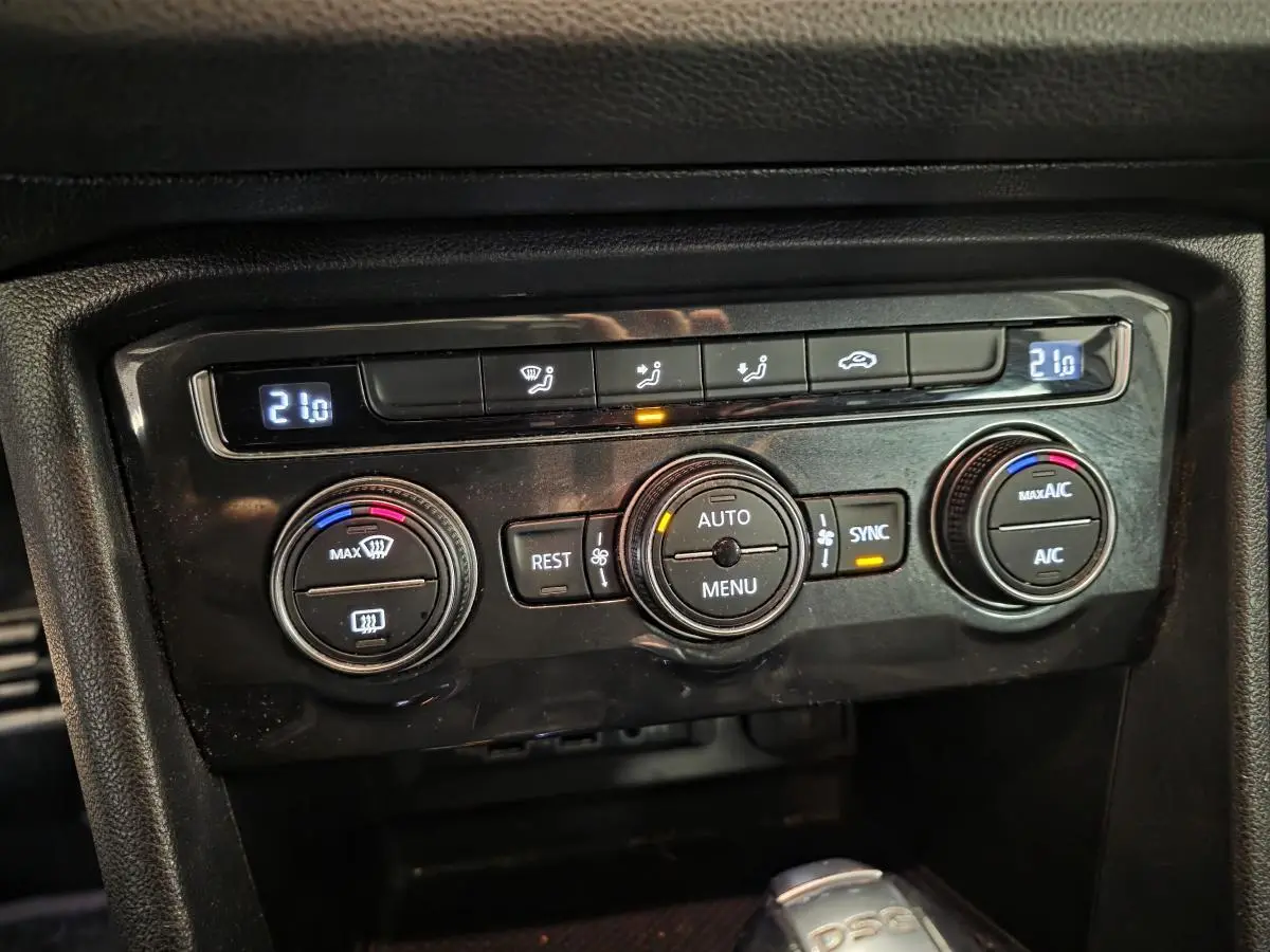 Gros plan sur la console centrale du Volkswagen Tiguan 2019 montrant les commandes de climatisation automatique tri-zone.