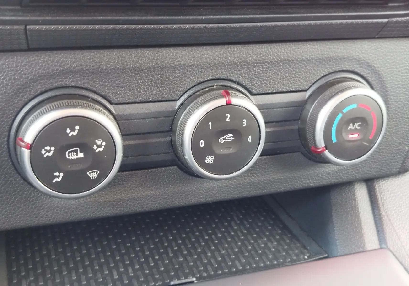 Gros plan sur les commandes de climatisation du Renault Kangoo 2023, avec réglages de ventilation, air recyclé et température.