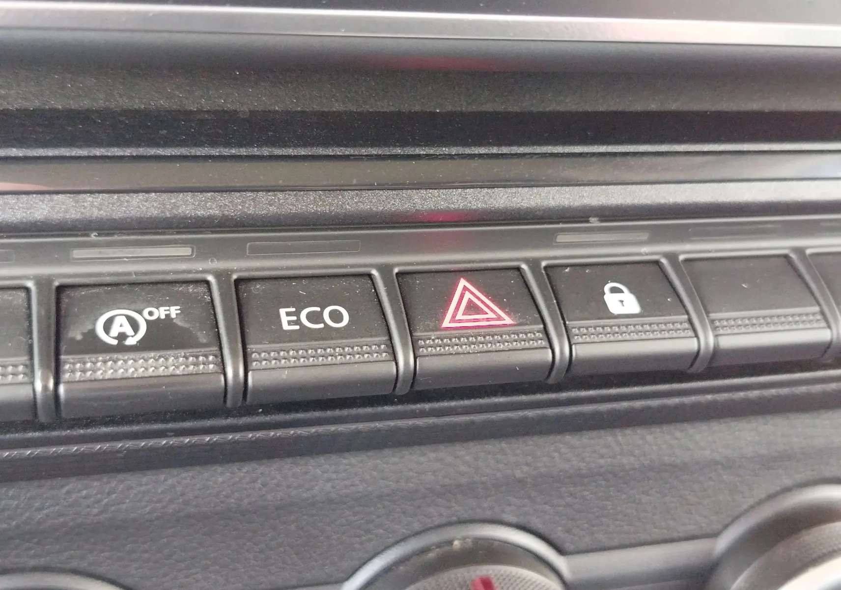 Gros plan sur les boutons de commande du tableau de bord du Renault Kangoo blanc, avec le bouton de warning allumé.
