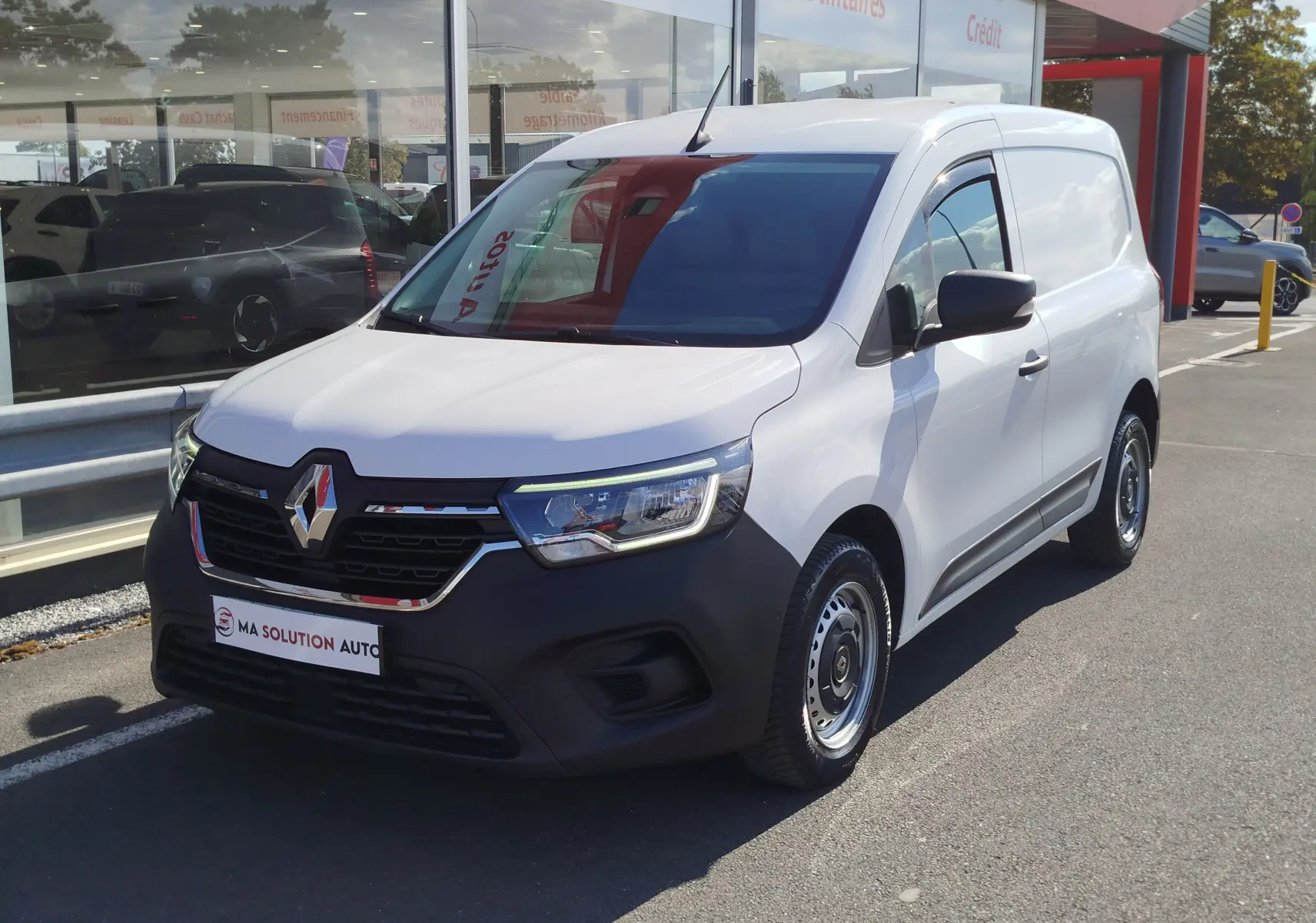 Renault Kangoo blanc minéral en 3/4 avant droit, fourgonnette utilitaire avec pare-chocs noir mat et jantes acier.