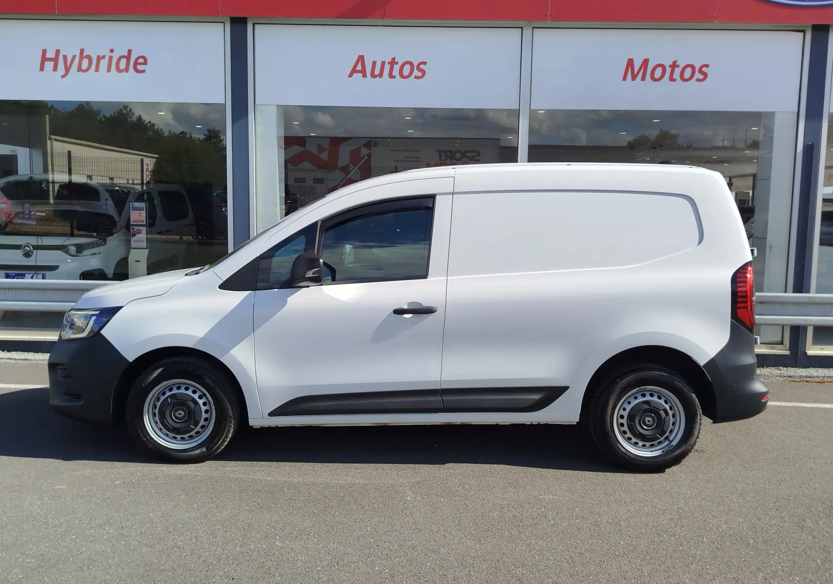 Vue de profil côté gauche d'un Renault Kangoo blanc Minéral 2023 avec jantes acier et protections noires.