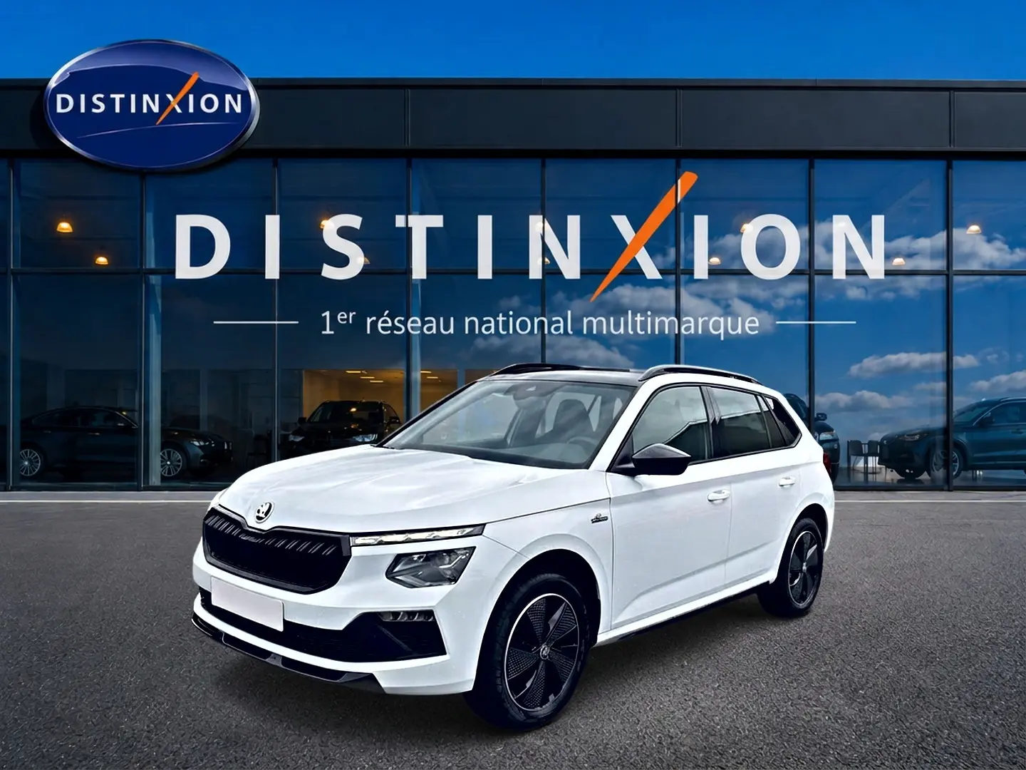 Skoda Kamiq blanc nacré en 3/4 avant droit, avec jantes noires et toit panoramique visible.