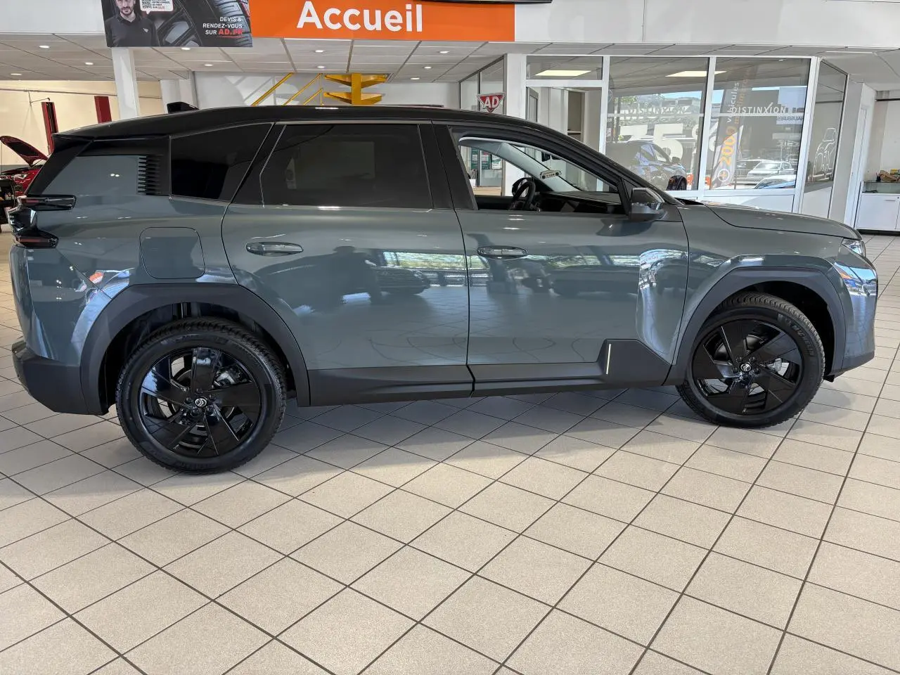 Vue de profil côté gauche du Citroën C5 Aircross vert métallisé avec jantes alliage noires en showroom.