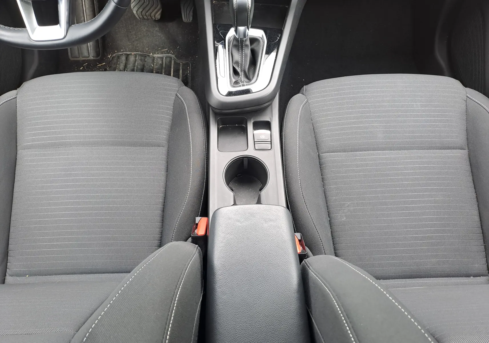 Vue plongeante sur les sièges avant en tissu noir et la console centrale avec levier de vitesse de la Renault Arkana 2023.