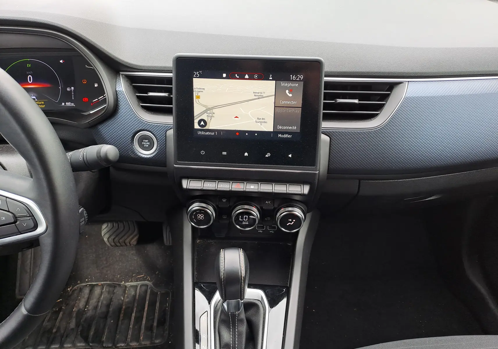 Vue intérieure centrale du tableau de bord du Renault Arkana 2023 avec écran tactile et levier de boîte automatique.