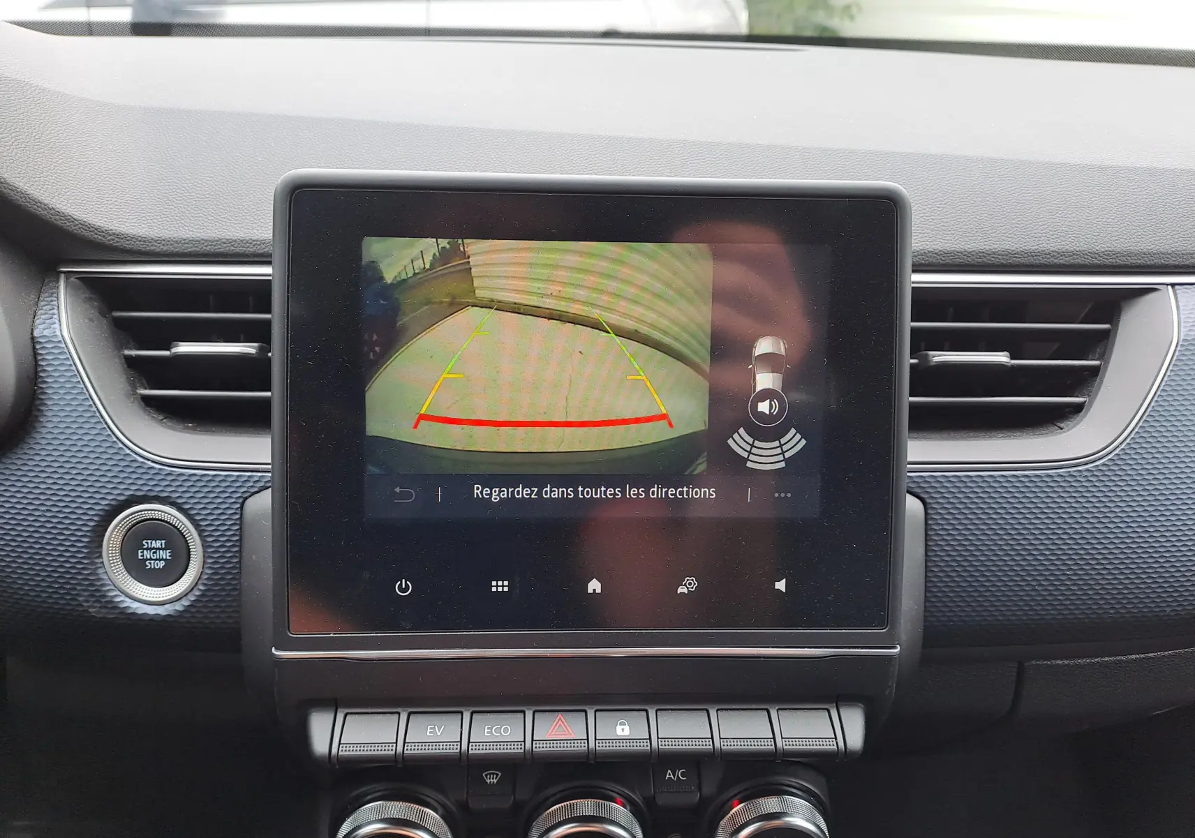 Écran central affichant la caméra de recul dans un Renault Arkana bleu Zanzibar 2023, avec tableau de bord noir texturé.