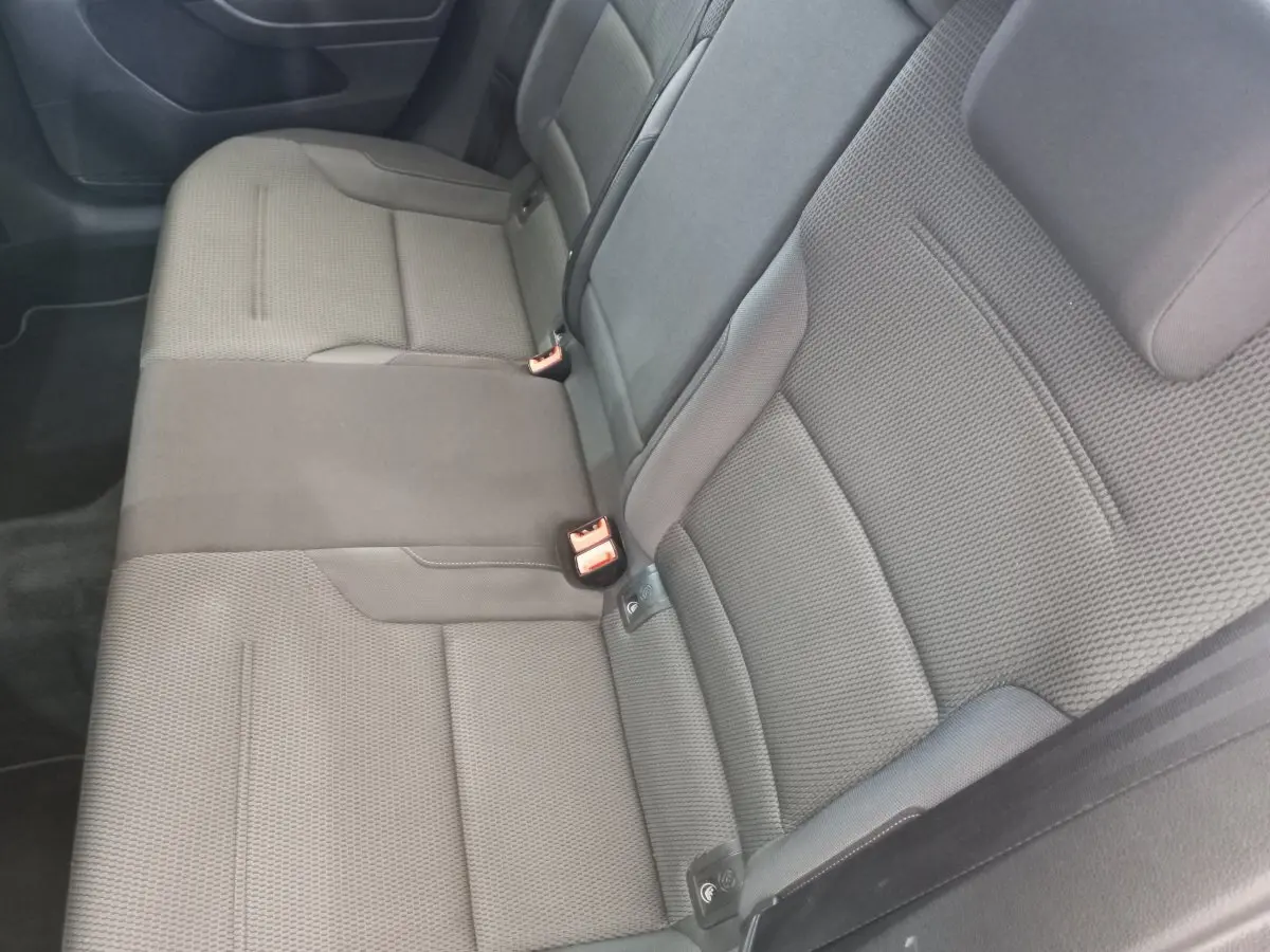 Banquette arrière gris foncé vue de côté gauche dans une Volkswagen Golf 2019, tissu texturé avec ceintures visibles.